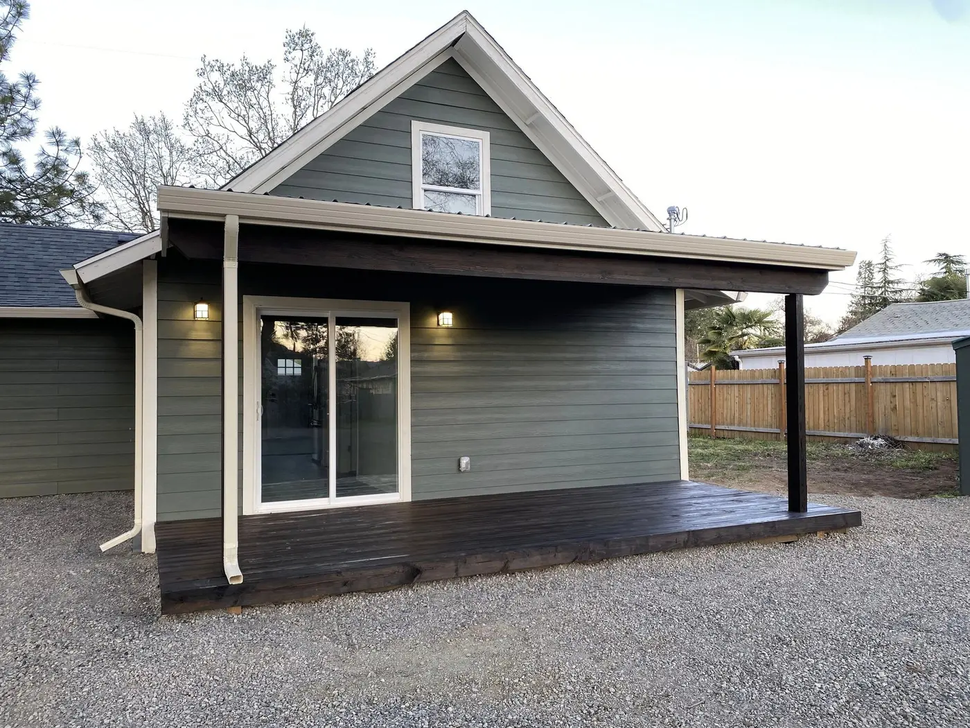 Home with modern gray lap siding and a covered porch with dark wood decking, by Next Gen Contracting in Southern Oregon