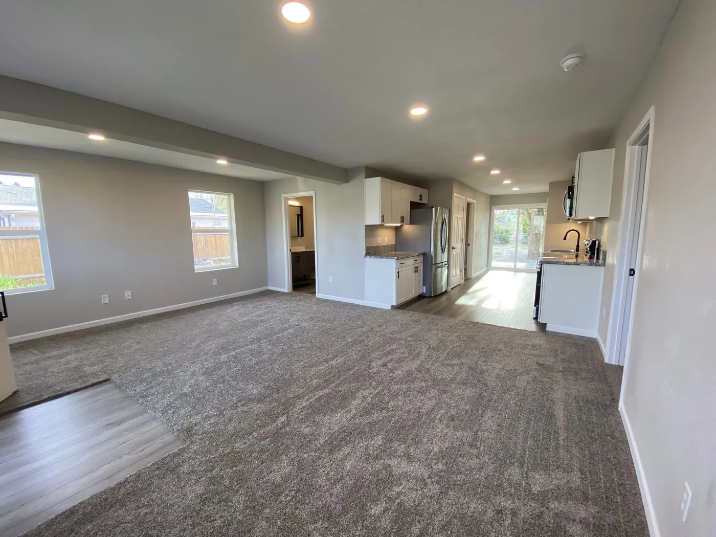 Open-concept kitchen and living area remodel with white cabinets by Next Gen Contracting in Southern Oregon