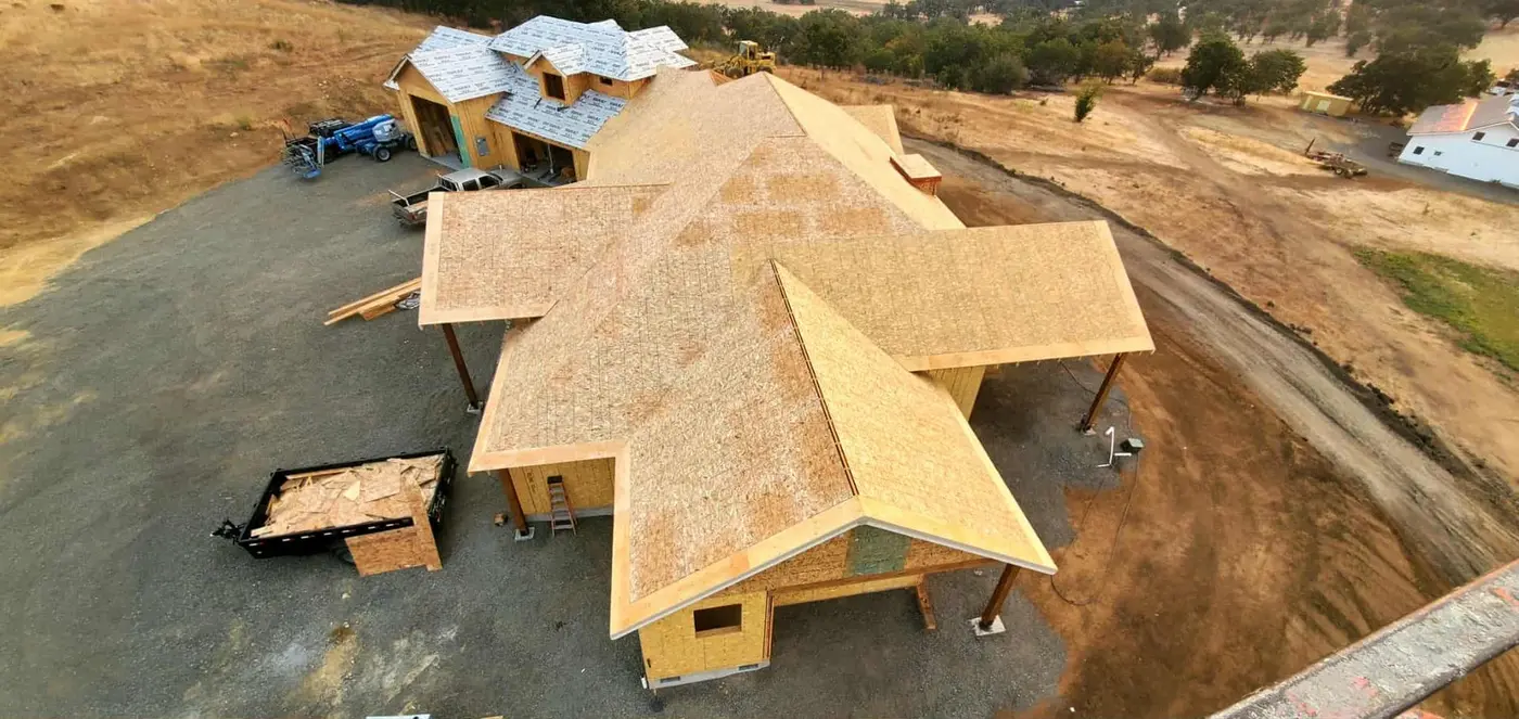 Aerial view of a home under construction with new roof sheathing and framed walls, Next Gen Contracting in Southern Oregon