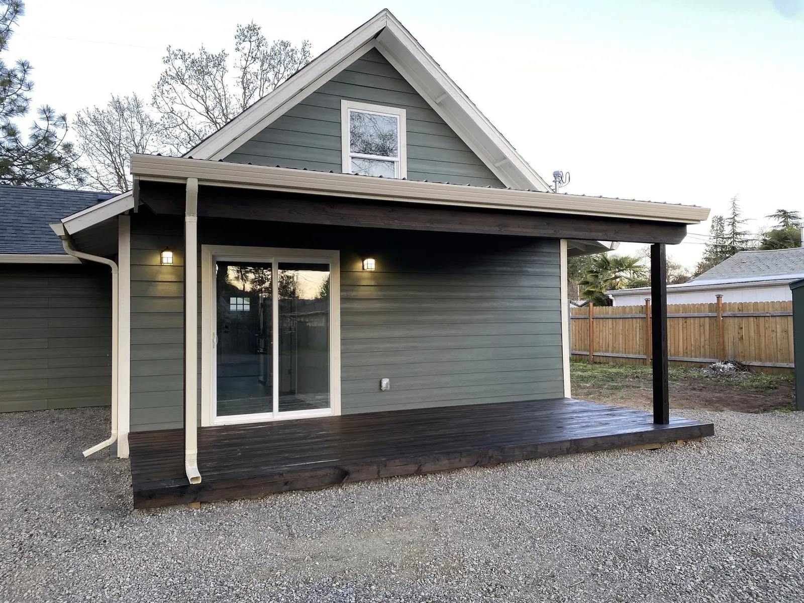 Home with sage-green lap siding, cream trim, and a covered porch by Next Gen Contracting in Southern Oregon