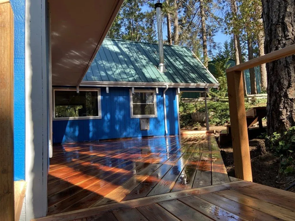 Natural wood deck and a wood-sided cabin among Southern Oregon evergreens, Next Gen Contracting